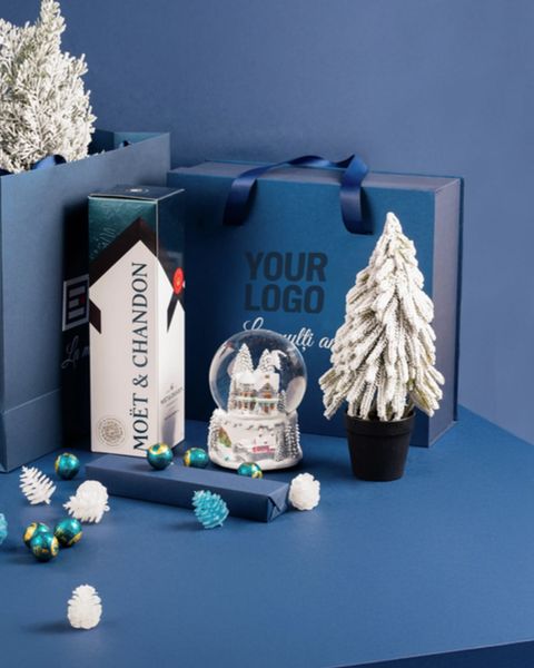 Setul cadou Blue Wish cu șampanie, glob cu zăpadă, brăduț decorativ, ceai și bomboane, într-o cutie albastră cu mânere